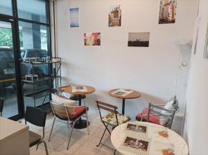 a room with two tables and chairs and a window at Merlin MANSION 107 in Ban Khlong Samrong