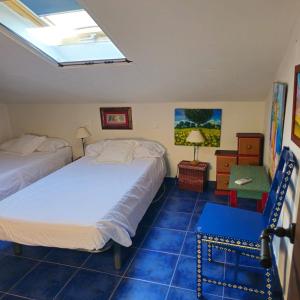 two beds in a room with blue tiled floors at LOS TASAJILLOS, Vivienda de uso Turístico in Candeleda