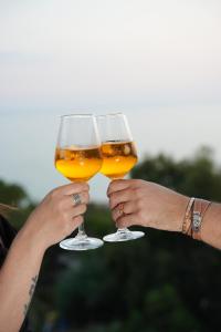 two people holding up two glasses of beer at Casa Barca - Luxury Apartment in Agrigento +14 photos