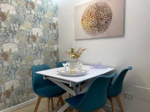 a dining room with a white table and blue chairs at La Chicca di Sofy in Orvieto