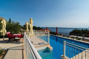 ein Swimmingpool mit Blick auf das Wasser in der Unterkunft Kuća za odmor R&A in Podstrana