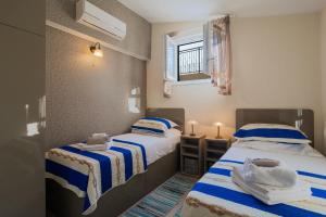 ein Zimmer mit zwei Betten und einem Fenster in der Unterkunft Kuća za odmor R&A in Podstrana + 22 Fotos