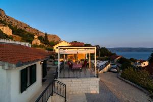 ein Haus mit einer Terrasse mit Blick auf das Wasser in der Unterkunft Kuća za odmor R&A in Podstrana