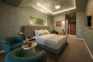 een hotelkamer met een bed en twee stoelen bij Hotel Sunce in Soko Banja
