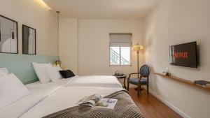 Postel nebo postele na pokoji v ubytování M Village Hotel Tao Đàn Park