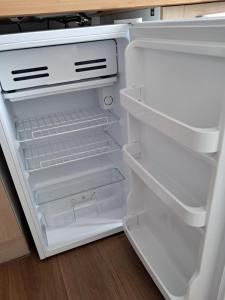 an empty refrigerator with its door open in a kitchen at LAETITIA ET CLAUDE in Lille