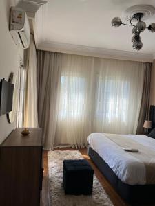 a bedroom with a bed and a dresser with a television at Madinty vg1 مجموعة ٨ فيلا ٤١ مدينتى فرش فندقى بلكامل in Madinaty