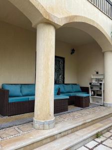 a porch with blue couches on a house at Madinty vg1 مجموعة ٨ فيلا ٤١ مدينتى فرش فندقى بلكامل in Madinaty
