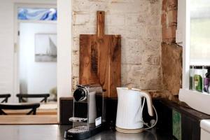 eine Küchentheke mit einer Kaffeemaschine und einem Toaster in der Unterkunft Tamara Cottage Historic Warmth in Hobart