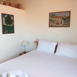 a bedroom with a bed with white sheets at Παραθαλάσσιο Studio in Agios Nikolaos