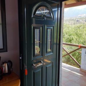 a green door in a room with a window at Παραθαλάσσιο Studio in Agios Nikolaos