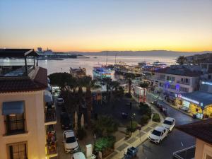 a city with cars parked on a street near the water at Grand Faik Hotel in Çeşme