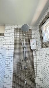 a shower in a tiled bathroom with a shower head at Picha house Kohyaonoi in Ban Laem Sai