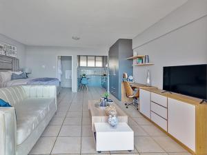 een woonkamer met een bank en een tv bij Luxury loft in Pretoria