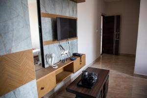 a living room with a television and a table at Serenity Stay Inn in Bangalore