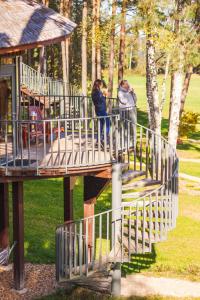 two people standing on a bridge in a park at LVM dabas parka glempings in Tērvete