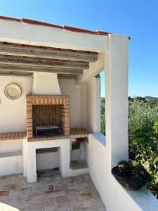 a patio with a fireplace on the side of a house at A casa dos avós in Abrantes