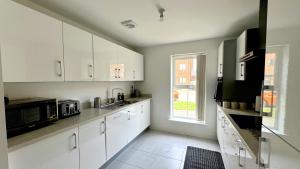 a kitchen with white cabinets and a window at 4 Hills Properties - Everest in Cross Gates +19 photos