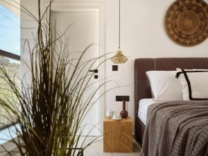 a bedroom with a bed and a potted plant at The White Luxury Villa - Private Seaview Villa with Pool by Villa Mana Gers in Vasilikos +56 photos