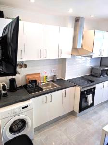 a kitchen with white cabinets and a sink at Vista Panorâmica Amadora Central in Amadora