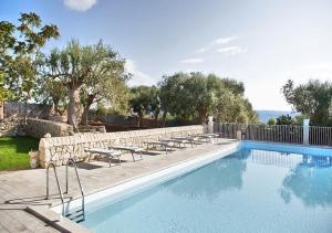 a swimming pool with tables and chairs next to a fence at Il Carosello dei Baroni in Noto