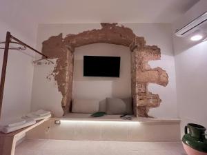 a room with a wall with a tv on it at Casa Vacanza Ada, A 2 Minuti Dal Mare, Relax Per Coppie in Marina di Mancaversa