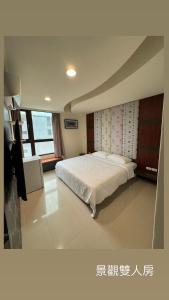 Un dormitorio con una cama y un televisor. en Guangming No 2 BnB, en Magong