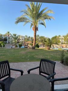 a patio with a table and chairs and a palm tree at Namaa Bay hotel Chalet in Sharm El Sheikh