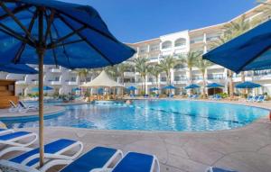a pool at a resort with chairs and umbrellas at Namaa Bay hotel Chalet in Sharm El Sheikh