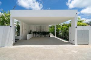 ラワイビーチにあるTropical Brand New 4BR Pool Villa Mina, just 5 min Drive from Naiharnのパビリオンのある白い建物の外観