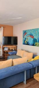 a living room with a blue couch and a flat screen tv at Apartments " Happy villa " in Splitska