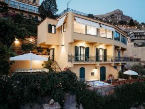 Un gran edificio con una piscina en frente. en Villa Marta Luxury Sea View and Spa, en Taormina