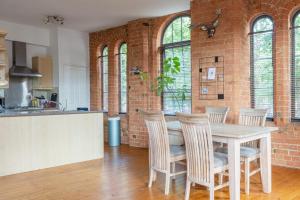 诺丁汉5 mins walk from centre, spacious city apt, open-plan的厨房设有砖墙和桌椅
