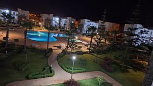 an aerial view of a large swimming pool at night at Résidence Perla Saidia-seulement pour les familles- Plage à 5 min à pieds - Piscine en travaux in Saïdia