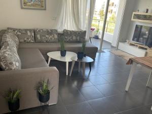 a living room with a couch and two tables with plants at Résidence Perla Saidia-seulement pour les familles- Plage à 5 min à pieds - Piscine en travaux in Saidia 