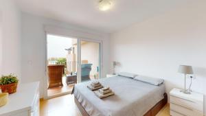 a white bedroom with a bed and a large window at Mar Menor Golf Resort in Murcia