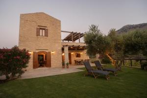 a brick house with two chairs in a yard at Kapediana Villa in Kapedhianá