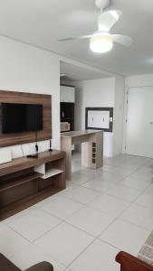 a living room with a television and a table at Apartamento em ótima localização in Torres +25 photos