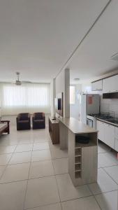 a large room with a kitchen and a living room at Apartamento em ótima localização in Torres