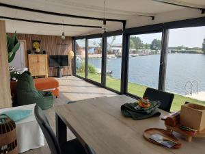 un soggiorno con tavolo e vista sull'acqua di Lakeside Wevelgem a Wevelgem