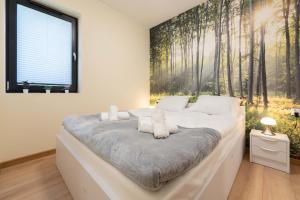 a bedroom with a bed with a forest mural on the wall at Apartamenty Słoneczne Tarasy z widokiem na góry - Dream Apart in Szczyrk