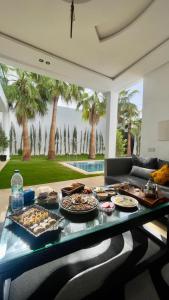 a table with food on it in a living room at Oasis TIFNIT Villa with Pool View No vis A vis in Draïd