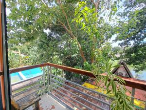 a balcony with a wooden railing and a swimming pool at The River House - Govantes Guesthouse in Vigan