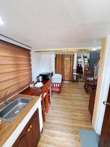 a kitchen with a sink and a living room at The River House - Govantes Guesthouse in Vigan
