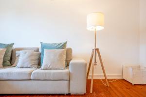 - un salon avec un canapé, des oreillers et une lampe de chevet dans l'établissement GuestReady - City views and comfort in Arroios, à Lisbonne