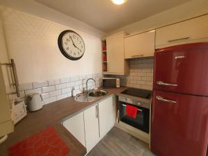a kitchen with a red refrigerator and a clock on the wall at 10 Pier Road Gillingham ME7 1RJ in Hoo +9 photos