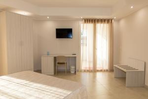 a bedroom with a bed and a desk and a television at Global Hotel in San Ferdinando