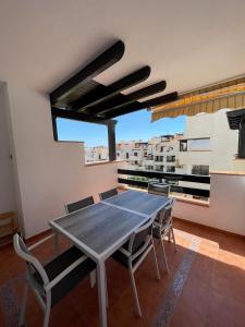 a dining room with a table and chairs on a balcony at Urbanización Altos de Nuevo Vera in Vera