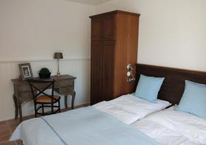 a bedroom with two beds and a desk with a chair at Romantik-Residenz Landhaus Greetsiel - B in Krummhörn