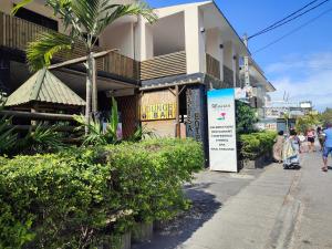 people walking down a sidewalk in front of a building at White Sand Cabana in Flic-en-Flac